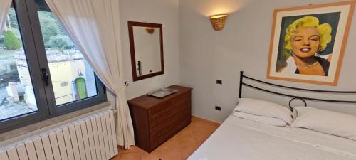 a bedroom with a bed and a painting on the wall at La Tana in Flumeri