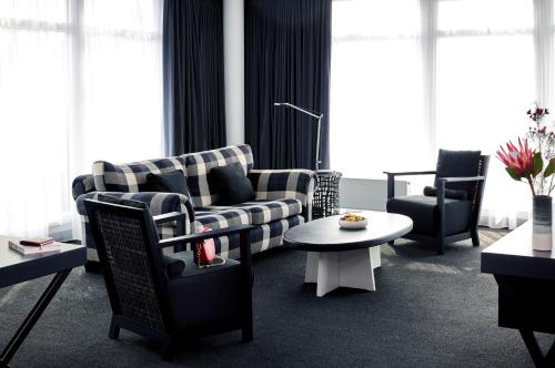 a living room with a couch and chairs and a table at THE MADISON Hotel Hamburg in Hamburg
