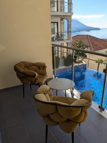 a balcony with a table and chairs and a swimming pool at Montenegro Royal 2 Bedroom Apartment in Becici