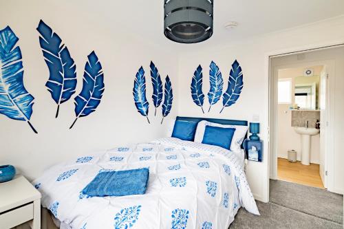 une chambre avec des plumes bleues et blanches sur le mur dans l'établissement Comfortable 4-Bedroom Heaven in Thetford, à Thetford