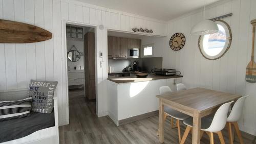 eine Küche und ein Esszimmer mit Tisch und Stühlen in der Unterkunft L escale du Bassin 800 m de la plage 3 pers in Andernos-les-Bains