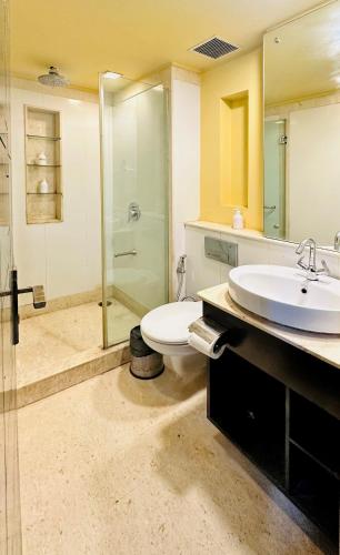 a bathroom with a sink and a toilet and a shower at Posh Suites - Golf Course Road in Gurgaon