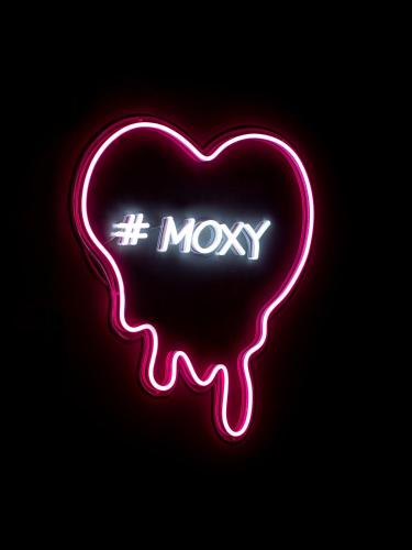 a neon sign with a heart with the word mosky at Moxy Vienna City East in Vienna