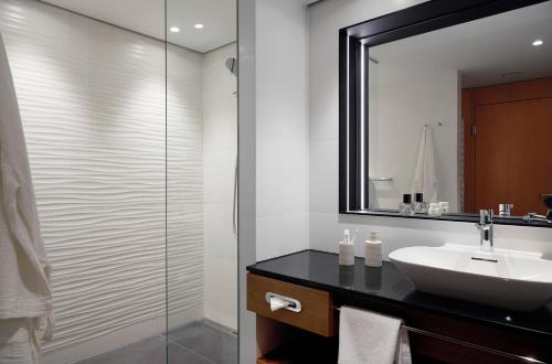 a bathroom with a sink and a mirror at THE MADISON Hotel Hamburg in Hamburg