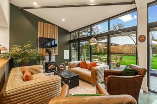 a living room with two couches and a fireplace at Dragons Barn with Hot Tub in Great Malvern