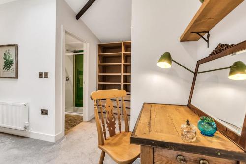 Un comedor con una mesa de madera y una lámpara. en Dragons Barn with Hot Tub, en Great Malvern