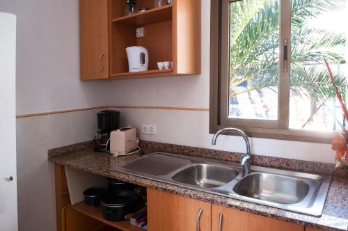 a kitchen counter with a sink and a window at Apartamento Playa Dor 17 in Cala d´Or