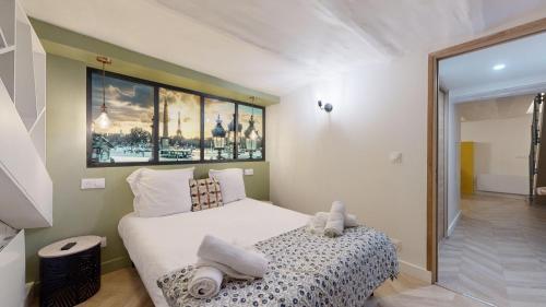 une chambre avec un lit et un tableau au mur dans l'établissement 180 Suite Steph - Superbe Appartement à Paris, à Paris