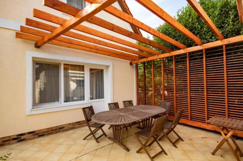 a patio with a wooden pergola and a table and chairs at Gurudeva Bhavan in Somogyvámos