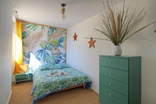 une chambre avec un lit avec une commode verte et une plante dans l'établissement Casa Viajano - Dépendance Villa Marseille, à Marseille