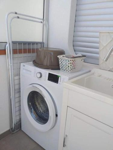 a washing machine and a sink in a bathroom at casa via del mare in Marina di Ragusa
