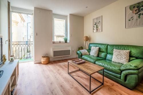 un salon avec un canapé vert et une table dans l'établissement Chaleureux appartement, centre ville, à Narbonne