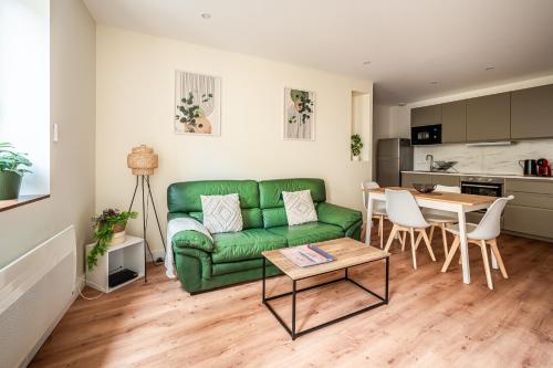 un salon avec un canapé vert et une table dans l'établissement Chaleureux appartement, centre ville, à Narbonne