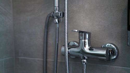 a shower in a bathroom with a faucet at NP Hotel Königshof in Dortmund