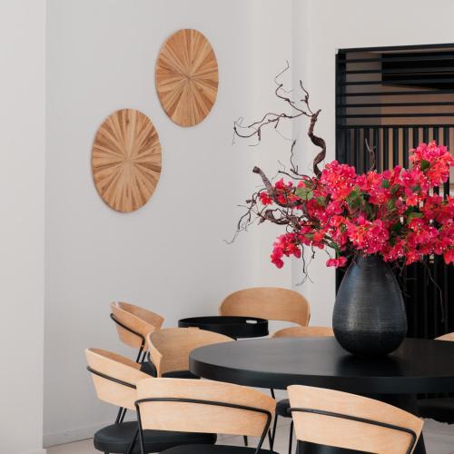 a table and chairs with a vase of red flowers at Abacus Suites in Ayia Napa