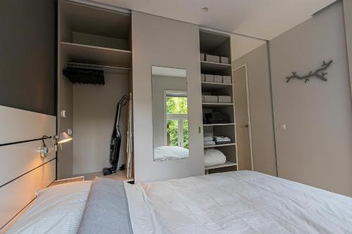 a bedroom with a large bed and a mirror at OHotellMe City Apartments Rotterdam in Rotterdam