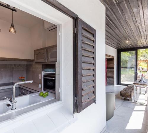 a kitchen with a large wooden door in the wall at La Douceur de l'Oise in Momignies