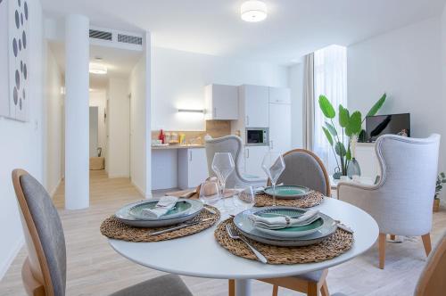 une salle à manger blanche avec une table et des chaises blanches dans l'établissement Résidence de Bourges, à Bourges