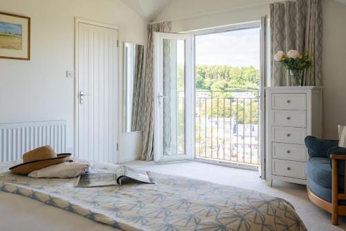 a bedroom with a bed and a large sliding glass door at Bluefin in Salcombe