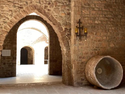 a room with a stone wall with a large stone bowl at Casa Rural Can Bastida in Cardona