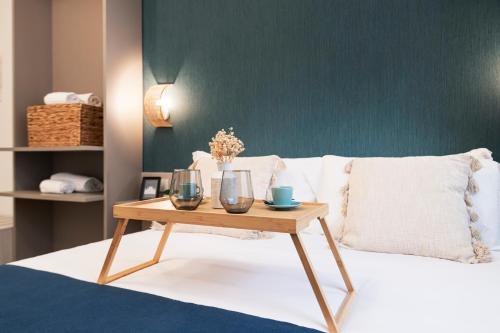 a bed with a table with two glasses on it at Easylife - FL Suite in Centrale in Milan