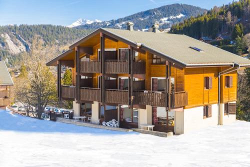 an apartment building with a balcony in the snow at Résidence Azureva La Clusaz les Aravis in La Clusaz
