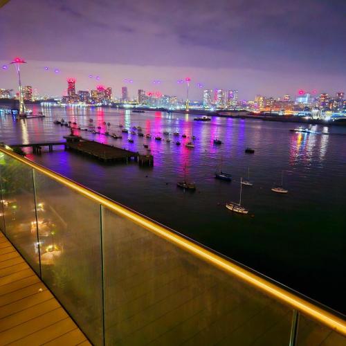 a view of a city at night with boats in the water at Waterfront- London Greenwich o2 Arena 2 Bed Flat in London