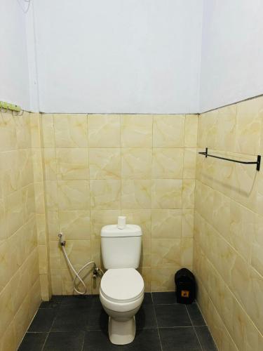 a bathroom with a white toilet in a stall at Biya Lumba in Candidasa
