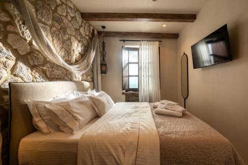 a bedroom with a bed with a stone wall at Maison Michelangelo in Arachova