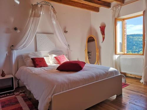 une chambre avec un lit avec des oreillers rouges et une fenêtre dans l'établissement Gite Via Nova, 12 personnes, 150 m2, à Lavoine