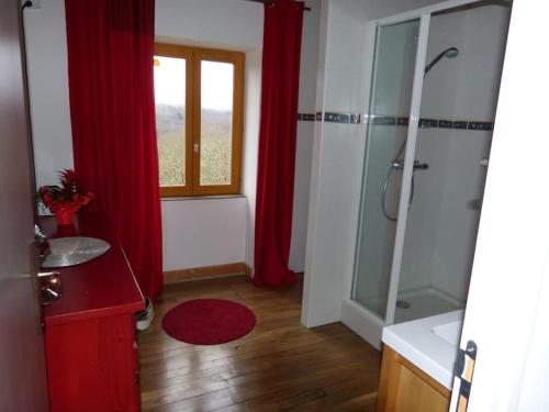 La salle de bains est pourvue d'une douche et d'un rideau rouge. dans l'établissement Gite Via Nova, 12 personnes, 150 m2, à Lavoine