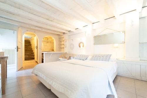 アルジェーニョにあるStorica Villa sul Lago di Como con darsena privataの白いベッドルーム(大型ベッド1台付)、キッチンが備わります。