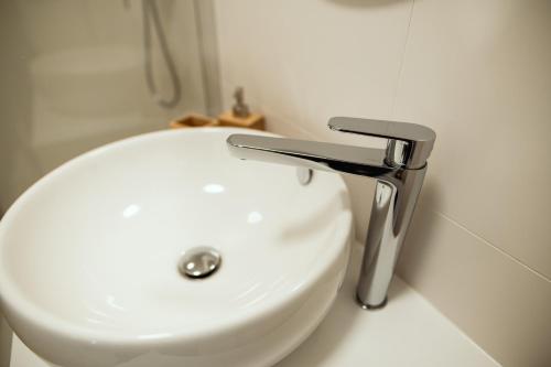 a white sink in a bathroom with aaucet at Anur Apartment in Ptuj