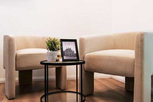 two chairs and a table with a picture on it at Easylife - FL Suite in Centrale in Milan