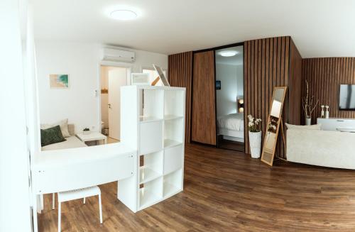 a white room with a bed and a mirror at Anur Apartment in Ptuj