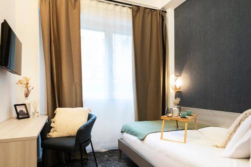 a hotel room with a bed and a chair and a window at Easylife - FL Suite in Centrale in Milan