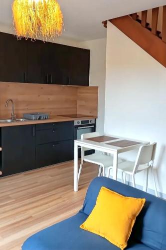 une cuisine avec un canapé bleu et une table dans l'établissement Petite maison avec jardin, à Landrévarzec