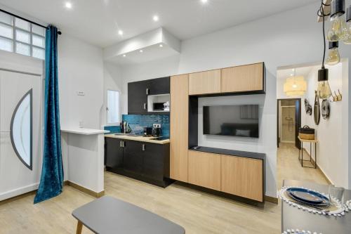 - une cuisine avec une grande télévision et un comptoir dans l'établissement Bluestay 8 - Charmant appartement à Paris 12, à Paris
