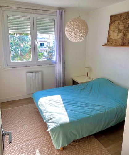 une chambre avec un lit bleu et une fenêtre dans l'établissement Le Quatro - 2ch - 2 lits doubles, à Villeurbanne
