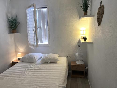 - une chambre avec un lit avec deux oreillers et une fenêtre dans l'établissement T2 cap d'agde, au Cap d'Agde