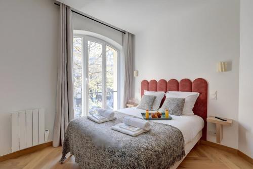 une chambre avec un grand lit avec une grande fenêtre dans l'établissement 343 Suite Jad - Superbe Appartement à Paris, à Paris