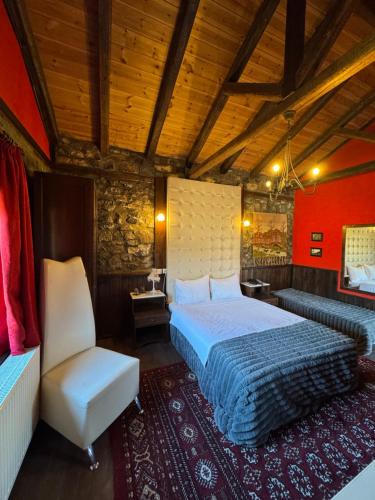 a bedroom with a bed and a chair in a room at Chalet Asteras tou Vorra in Palaios Agios Athanasios