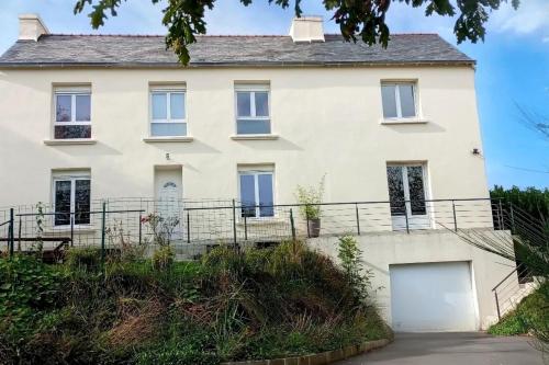 una grande casa bianca con un vialetto d'accesso di Petite maison avec jardin a Landrévarzec