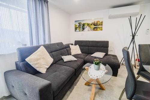 a living room with a couch and a table at Apartment Trta with Vineyard View in Bistrica ob Sotli