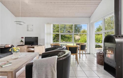 a living room with a couch and a fireplace at Beautiful Home In Væggerløse With Sauna in Bøtø By
