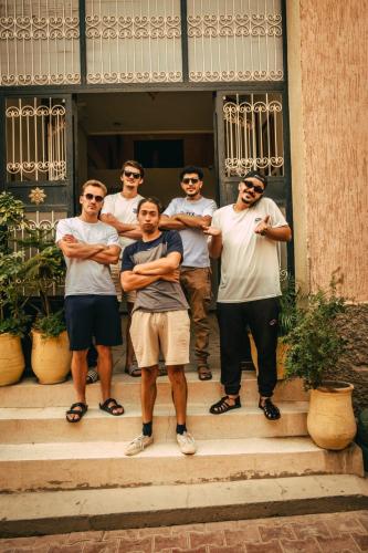 a group of men standing on steps in front of a house at Afgo Hostel in Ouarzazate