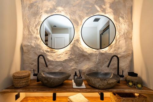 two sinks in a bathroom with two mirrors at Maison Michelangelo in Arachova
