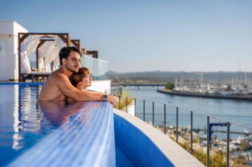 a man and a woman standing in a swimming pool at Jupiter Marina Hotel - Couples & Spa in Portimão