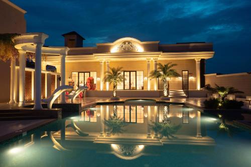 a large house with a swimming pool at night at La Nature Hotels & Resorts in Sīkar