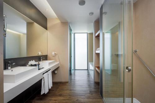a bathroom with two sinks and a shower at Jupiter Marina Hotel - Couples & Spa in Portimão